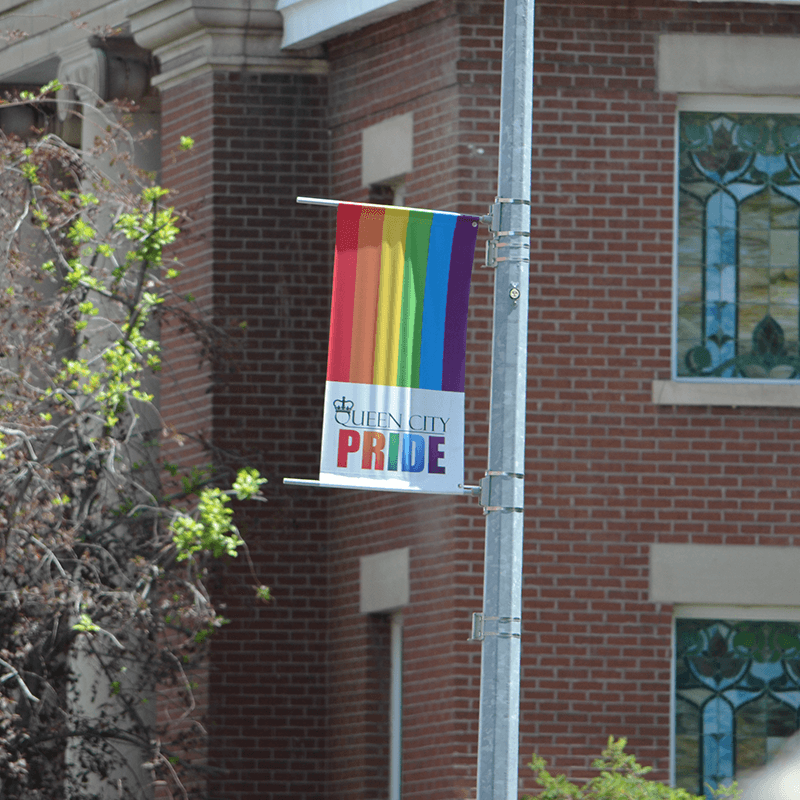 A rainbow-coloured streetlight banner with Queen City Pride's logo on display on a light pole in downtown Regina A rainbow-coloured streetlight banner with Queen City Pride's logo on display on a light pole in downtown Regina